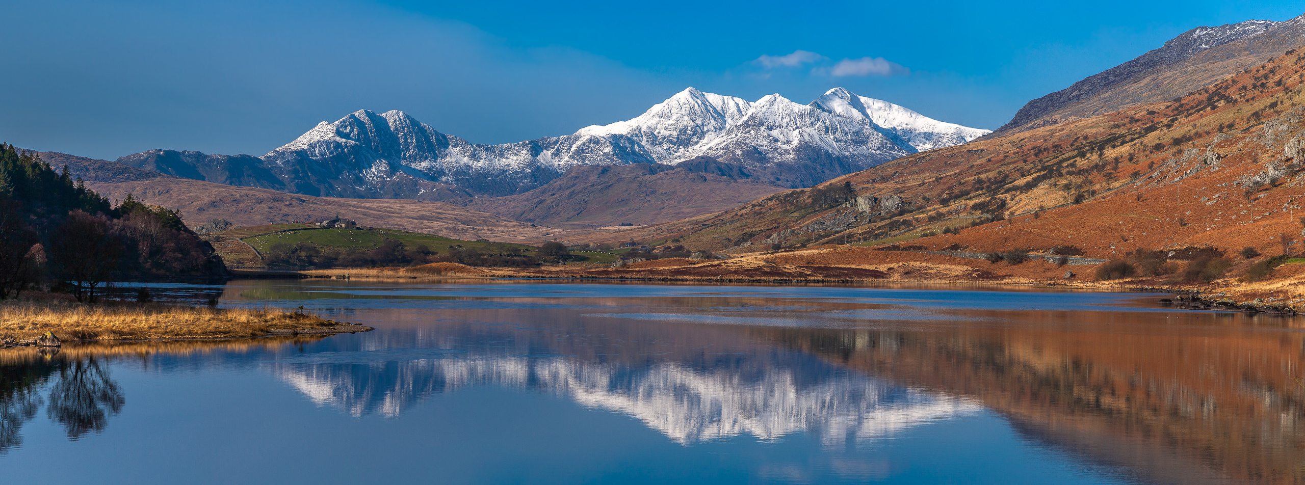 Spring snow on the peaks of the Snowdon Horseshoe reflected in the Llynnau Mymbyr