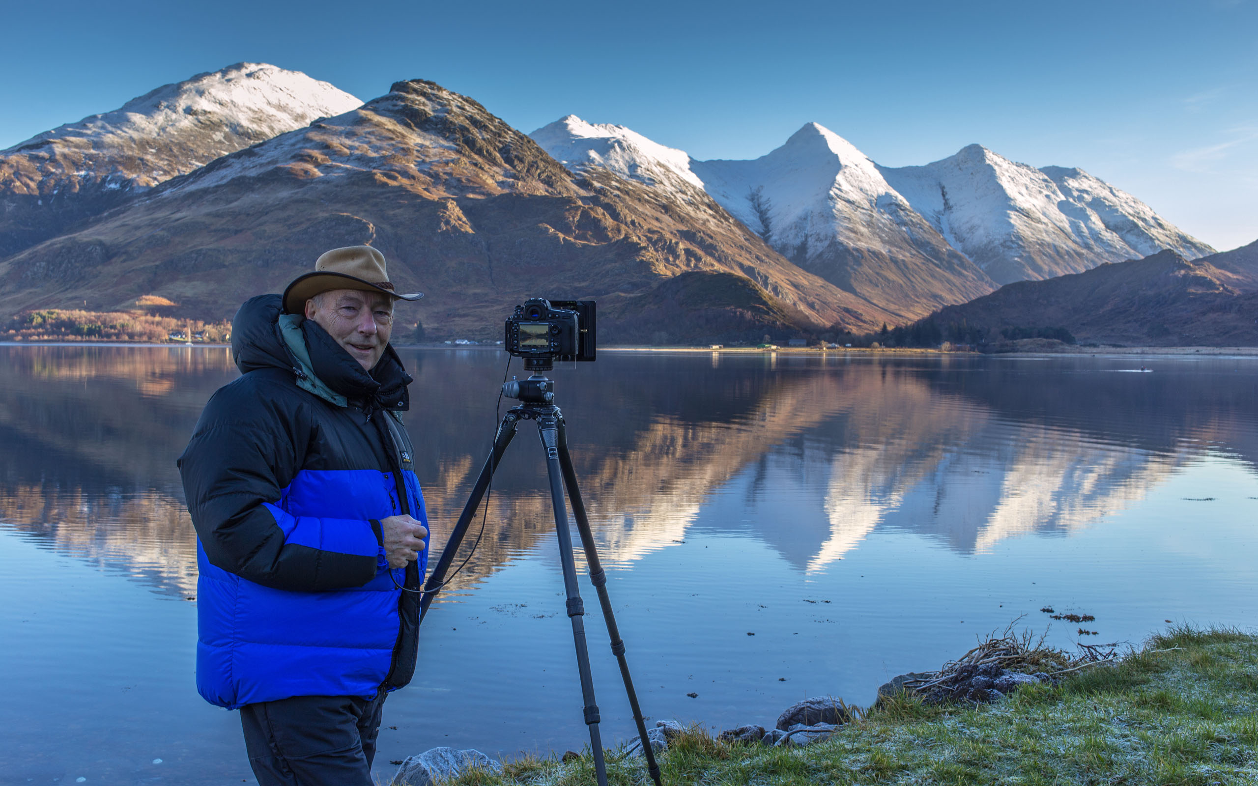 Ian Evans photographing the Five Sisters of Kintail in winter raiment across Loch Duich.